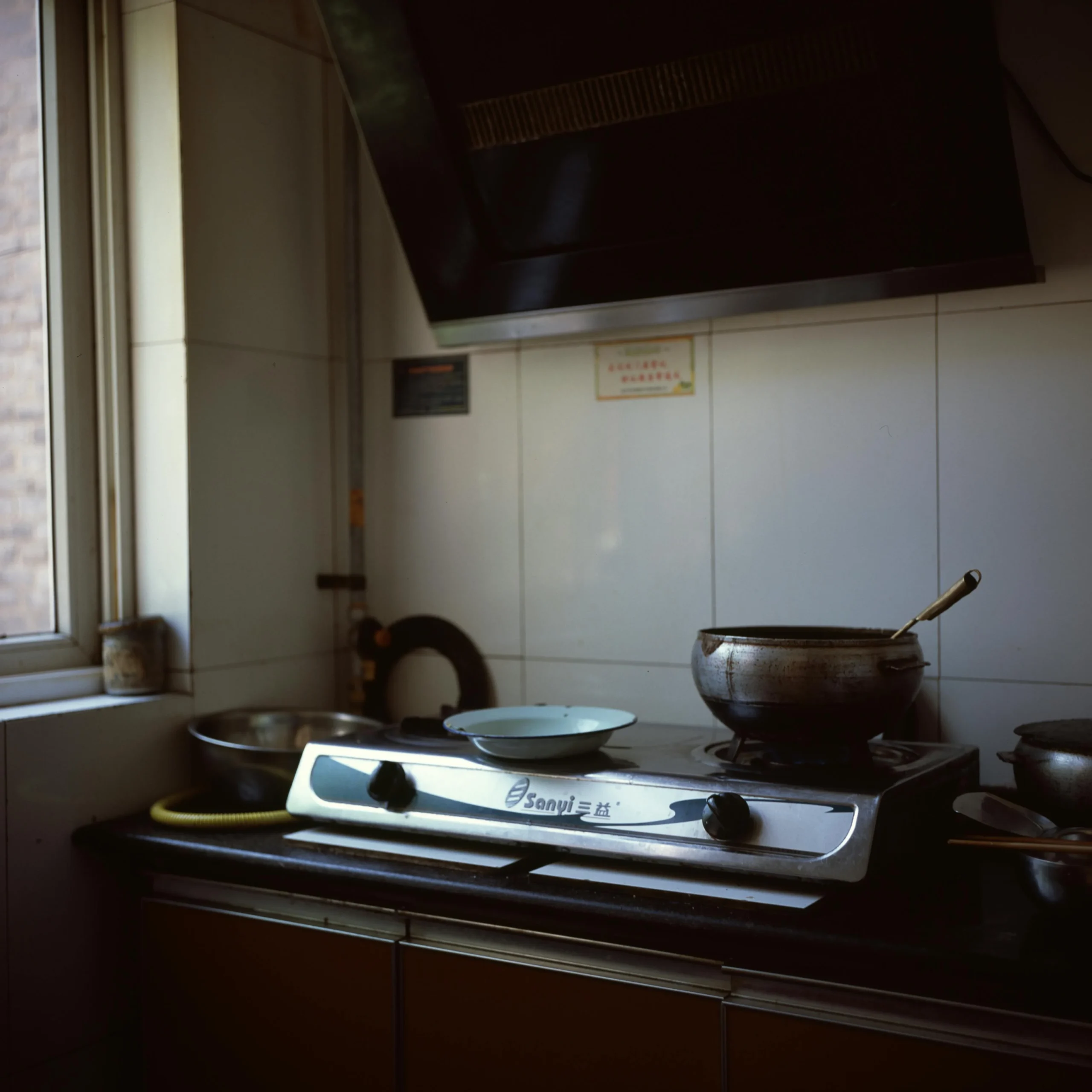 Modern kitchen stove with cooking pots and utensils near window – daily home cooking essentials